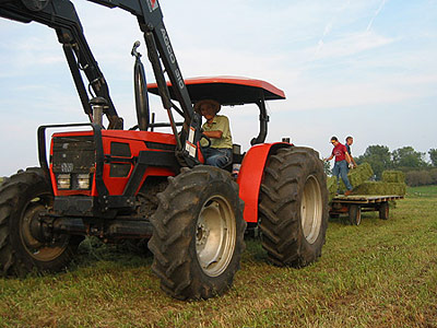 Wayne, Colton (friend), and Joseph baling alfalfa hay, September 2005